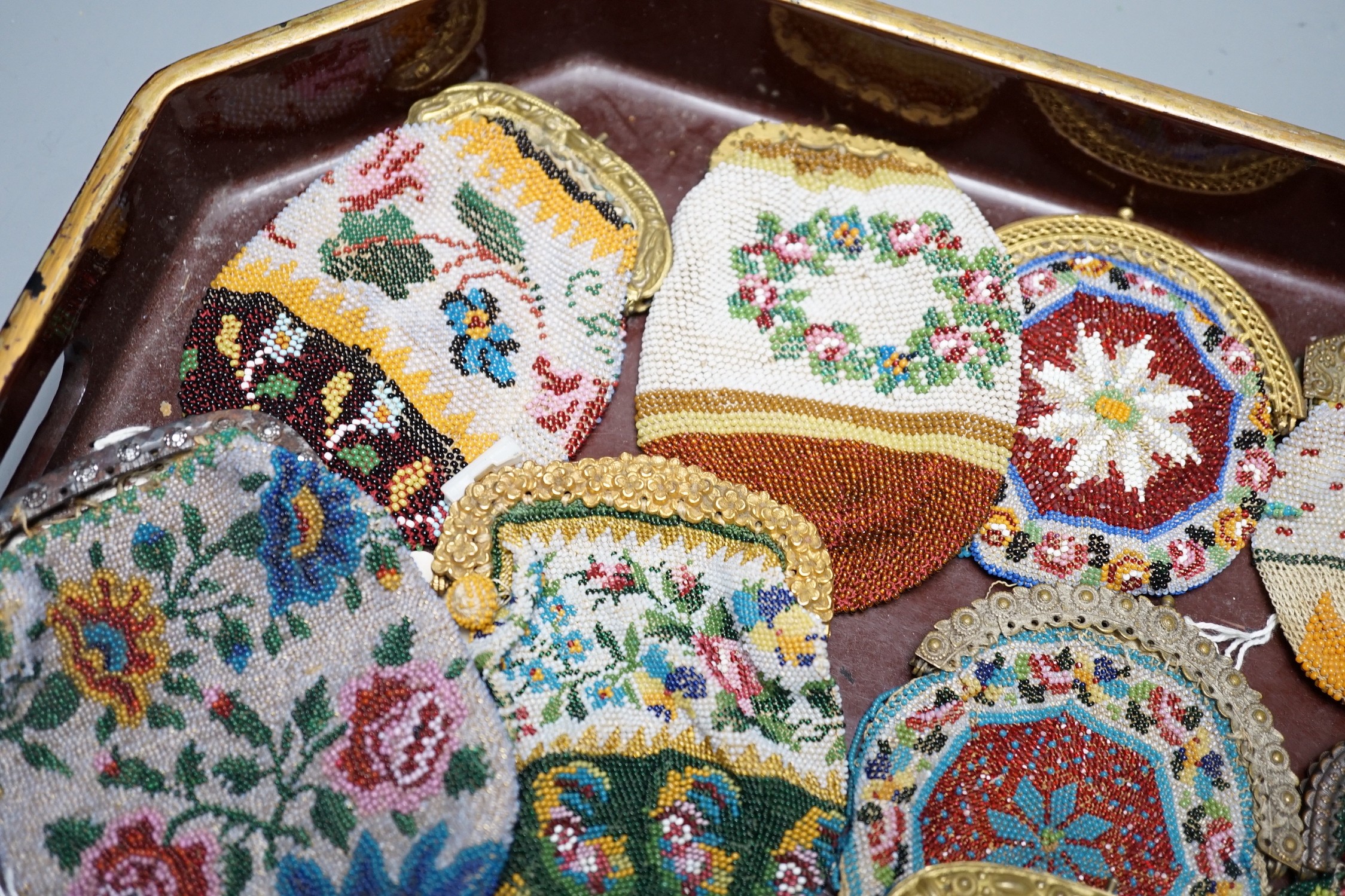 Twenty mid-19th century Berlin beadwork purses with gilt-metal frames, largest 10cm